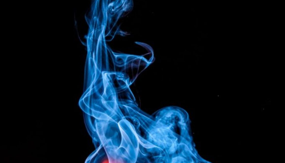 lighted match with smoke on black background